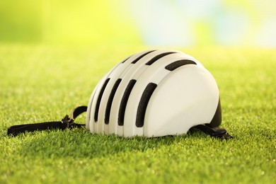 Photo of One white protective helmet on green grass