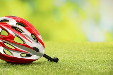 Photo of Colorful protective helmet on green grass, space for text