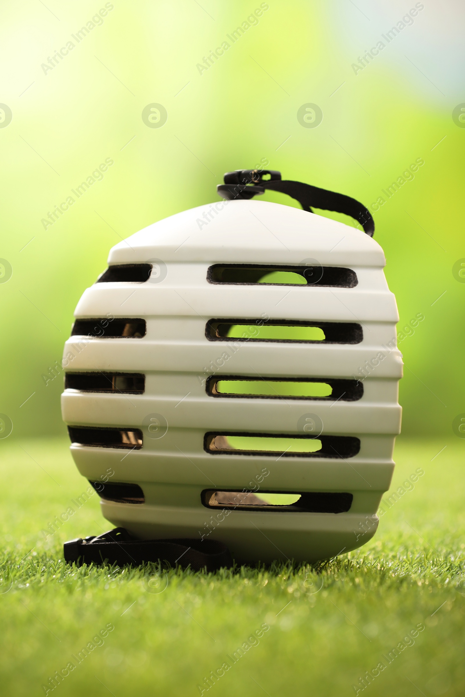 Photo of One white protective helmet on green grass