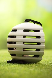 Photo of One white protective helmet on green grass