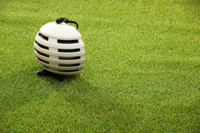 Photo of White protective helmet on green grass, space for text