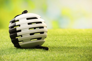 White protective helmet on green grass, space for text