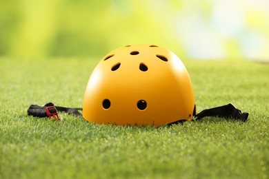 One yellow protective helmet on green grass