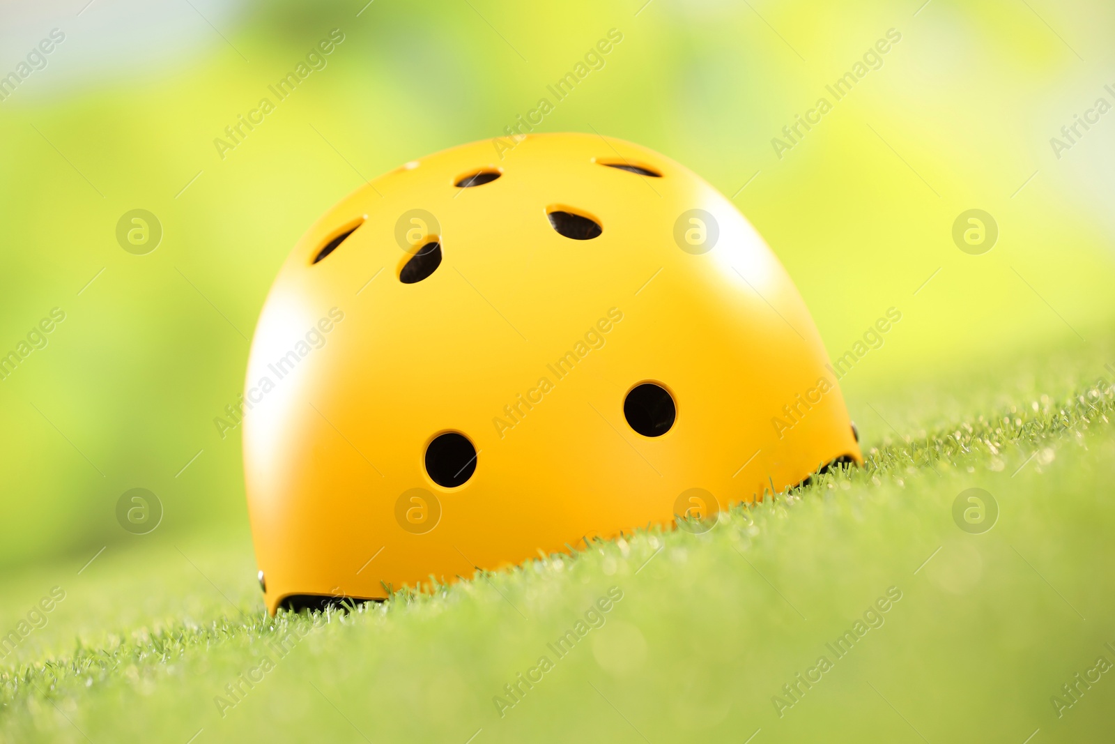 Photo of Yellow protective helmet on green grass, closeup