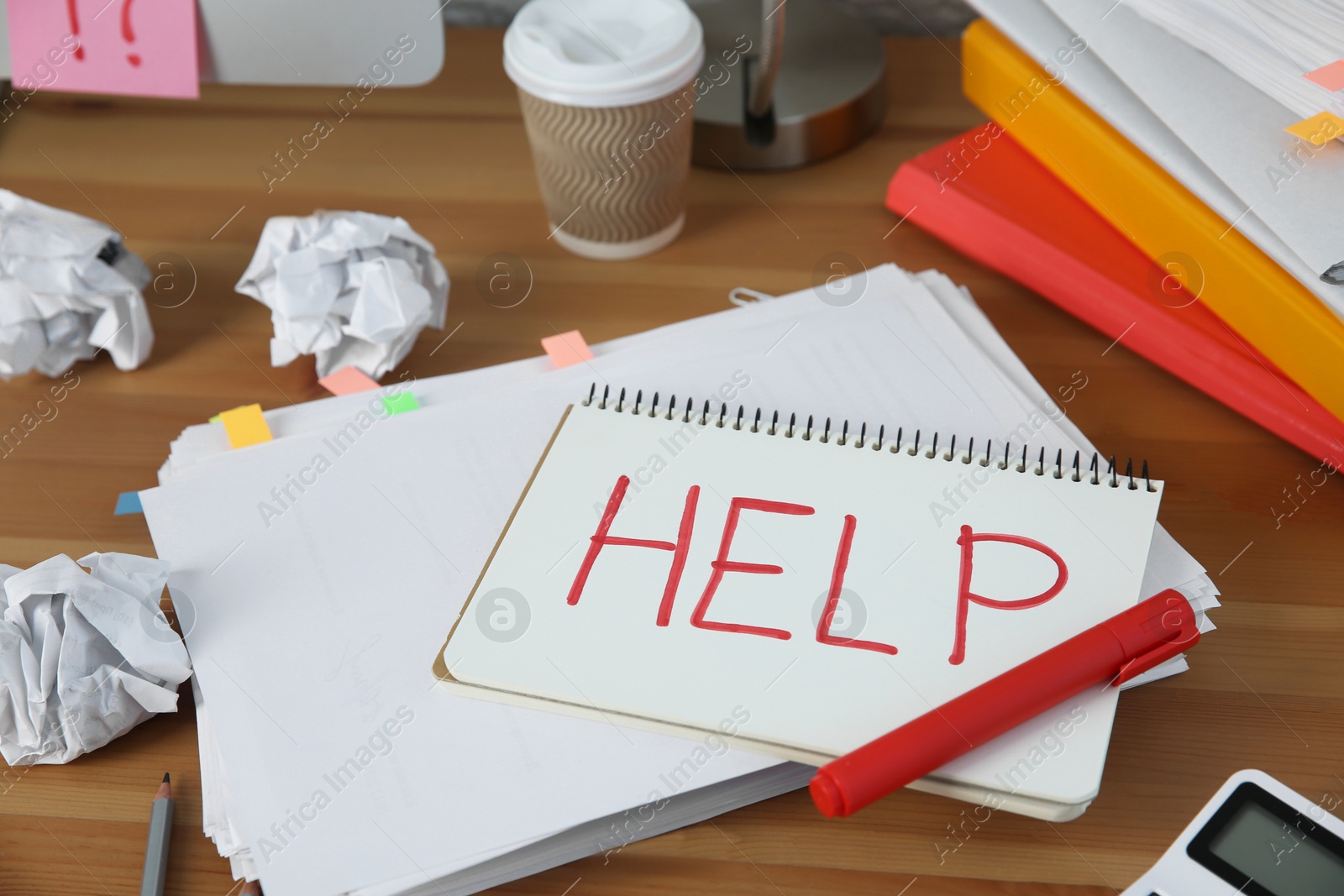 Photo of Notebook with word Help and stationery on wooden table at workplace