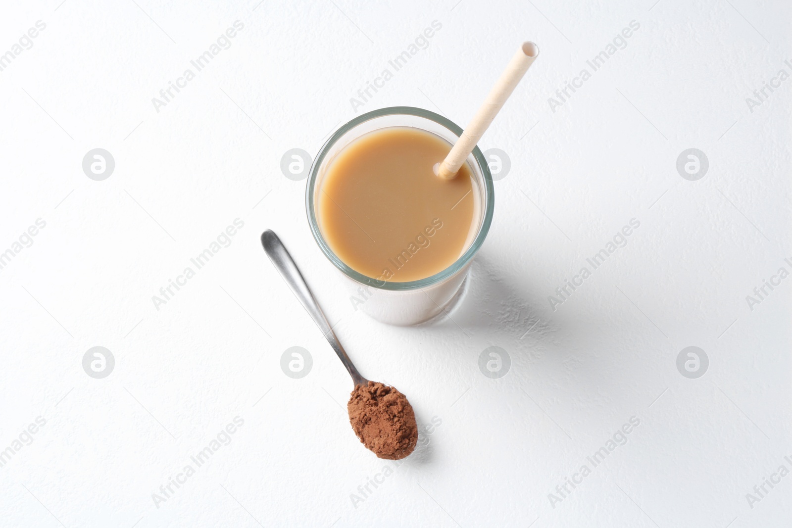 Photo of Delicious protein shake in glass and spoon with powder on white background, top view