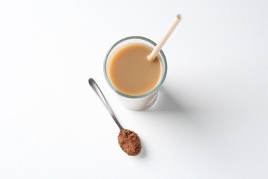 Photo of Delicious protein shake in glass and spoon with powder on white background, top view