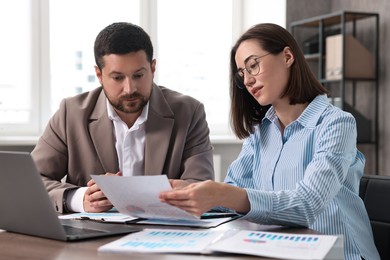 Consultant working with client at table in office