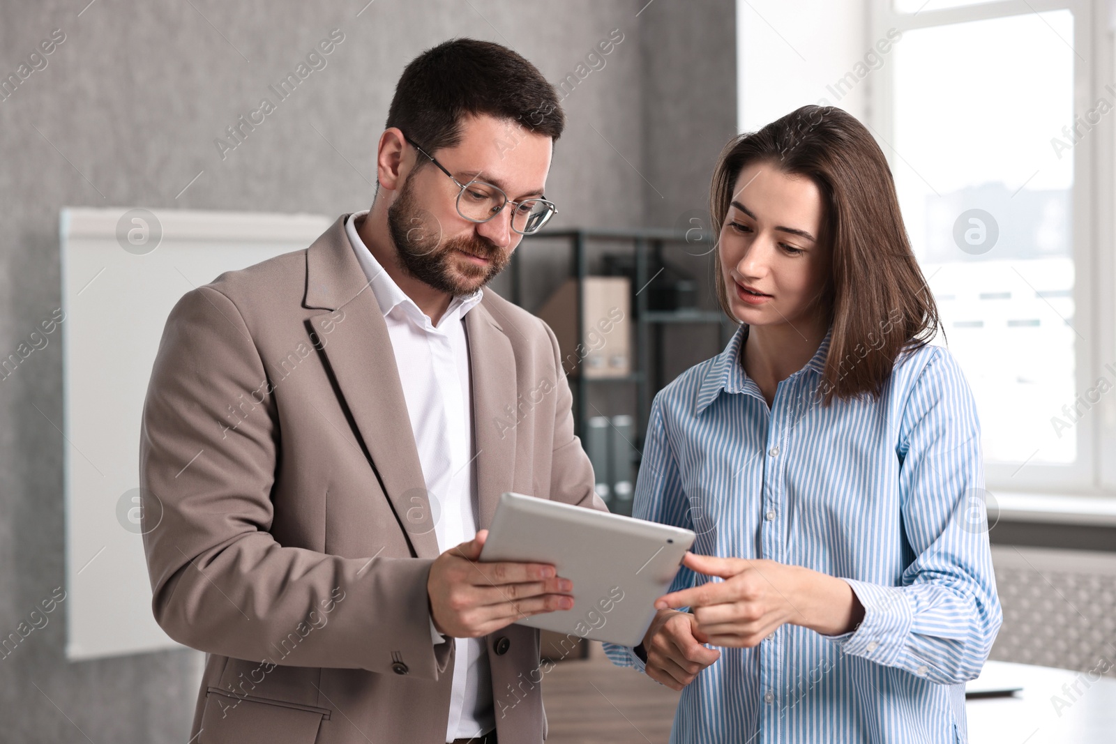 Photo of Young consultant working with client in office