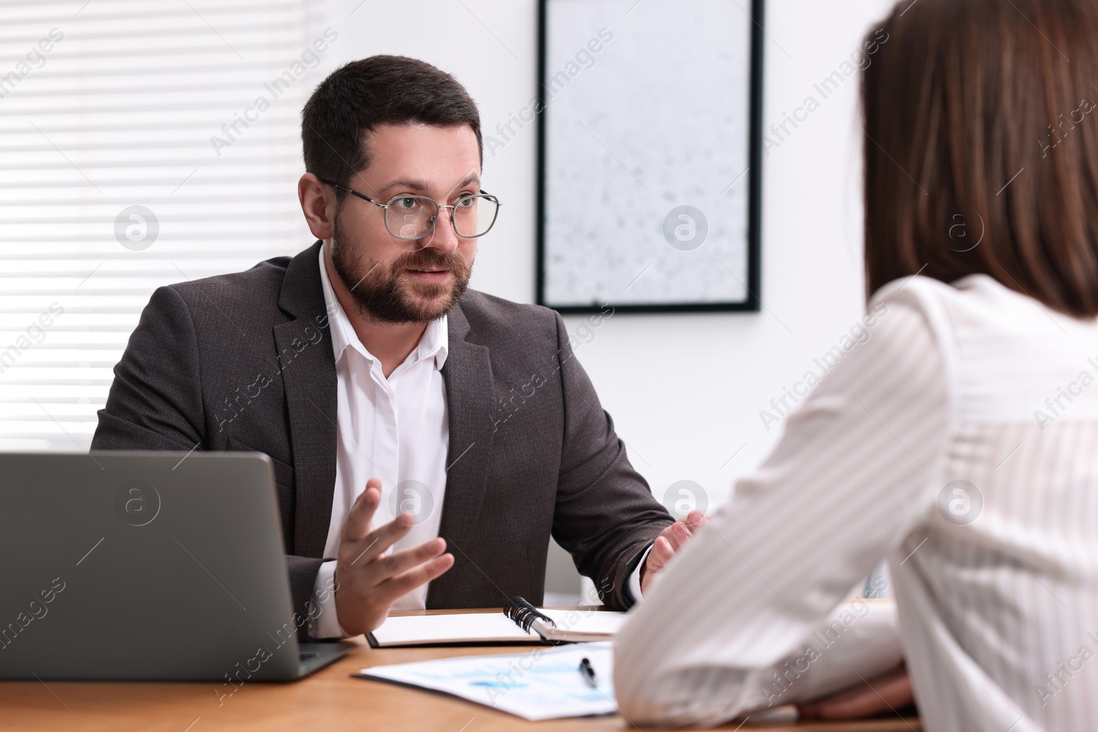 Photo of Consultant working with client at table in office