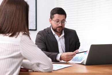 Consultant working with client at table in office