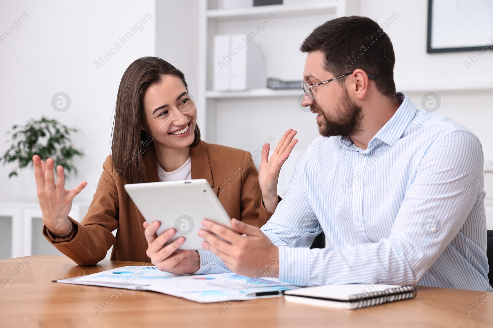 Photo of Consultant working with client at table in office