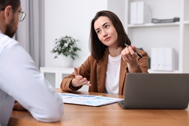 Consultant working with client at table in office