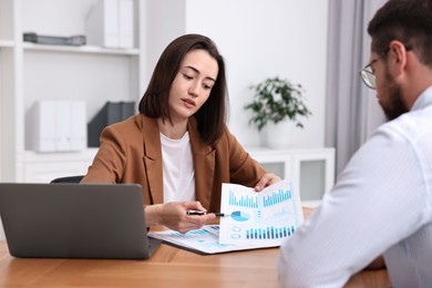 Photo of Consultant working with client at table in office