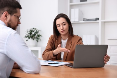 Consultant working with client at table in office