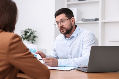 Consultant working with client at table in office