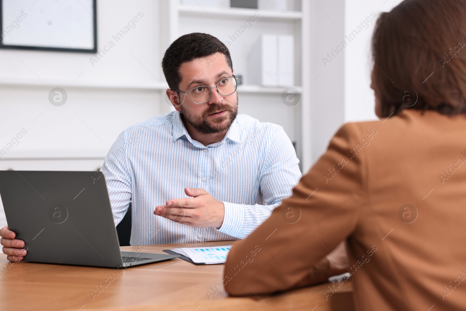 Photo of Consultant working with client at table in office