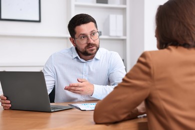 Photo of Consultant working with client at table in office