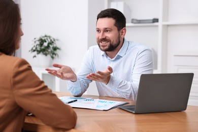 Consultant working with client at table in office