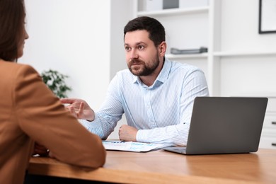 Photo of Consultant working with client at table in office