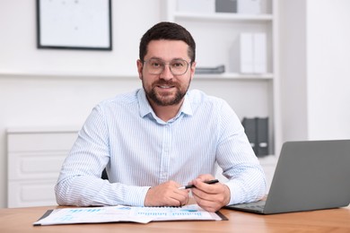 Consultant working with documents at table in office