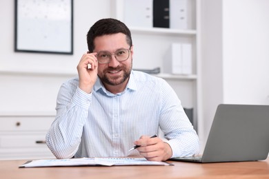 Consultant working with documents at table in office