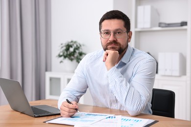 Consultant working with documents at table in office