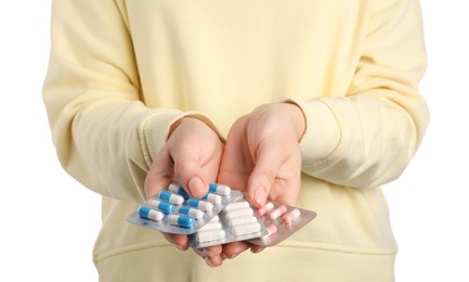 Photo of Woman holding blisters with antibiotic pills on white background, closeup