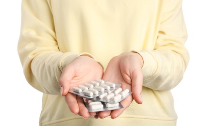 Photo of Woman holding blisters with antibiotic pills on white background, closeup