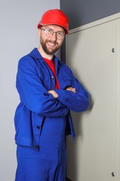 Photo of Happy electrician wearing uniform near electric meter box