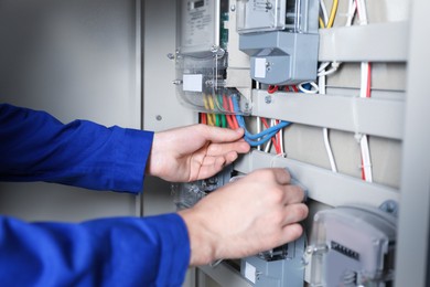 Photo of Electrician installing electricity meter indoors, closeup view