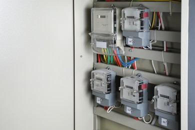 Photo of Electric meters and wires in fuse box, space for text. Energy measuring device