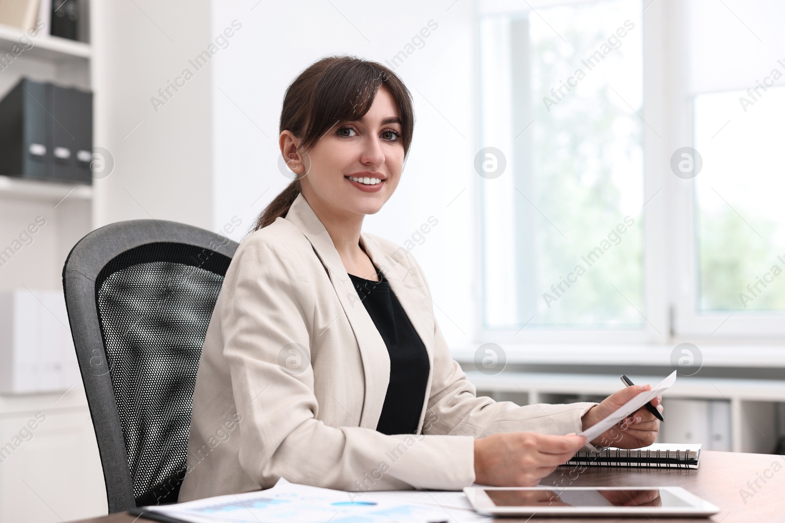 Photo of Portrait of smiling business consultant at table in office