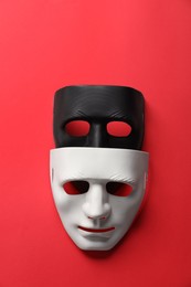 Theater arts. White and black masks on red background, top view