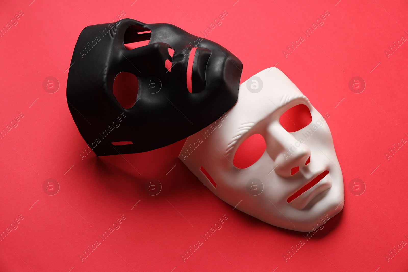 Photo of Theater arts. White and black masks on red background