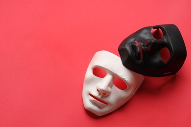 Photo of Theater arts. White and black masks on red background, above view. Space for text