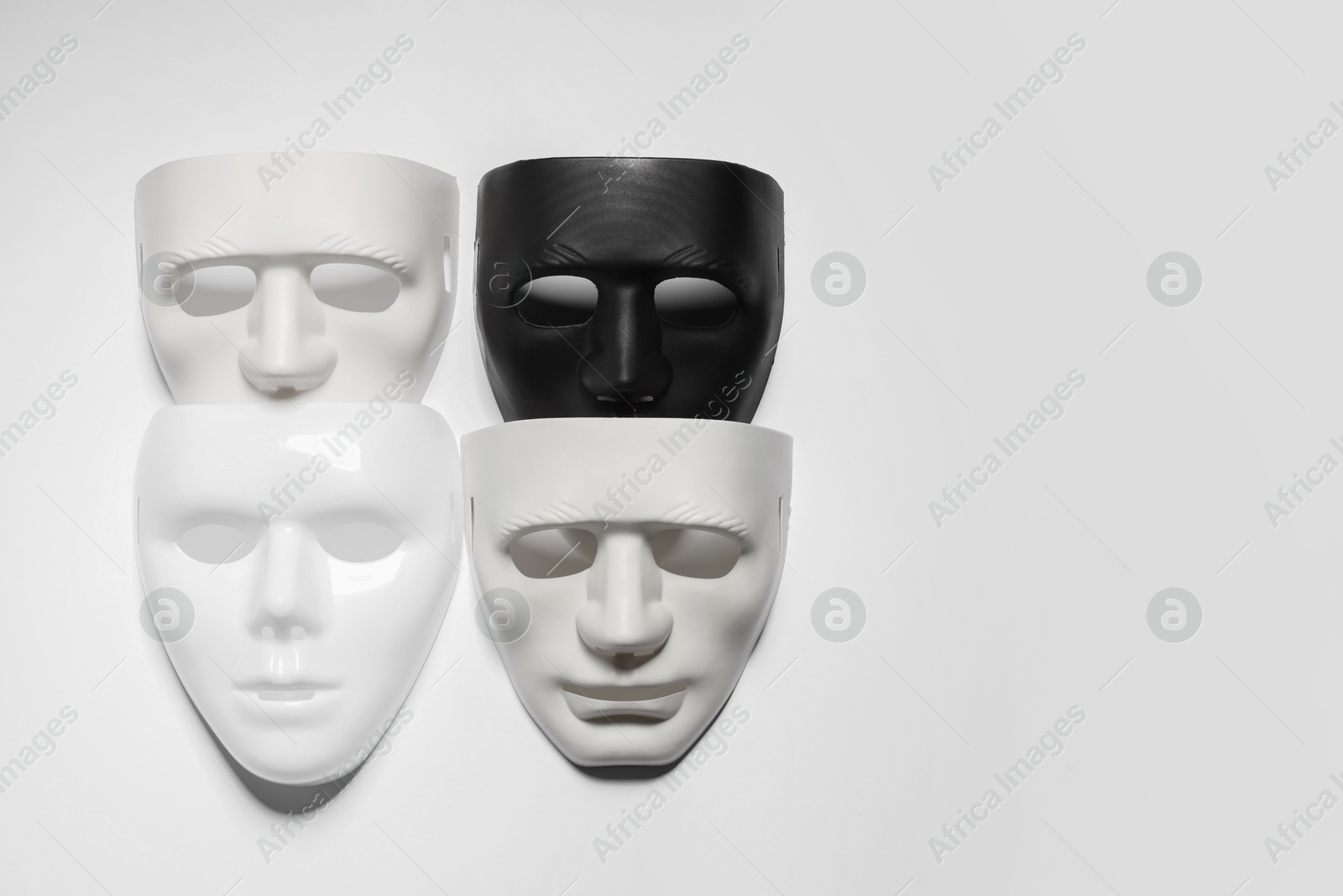 Photo of Theater arts. Many masks on light background, top view. Space for text