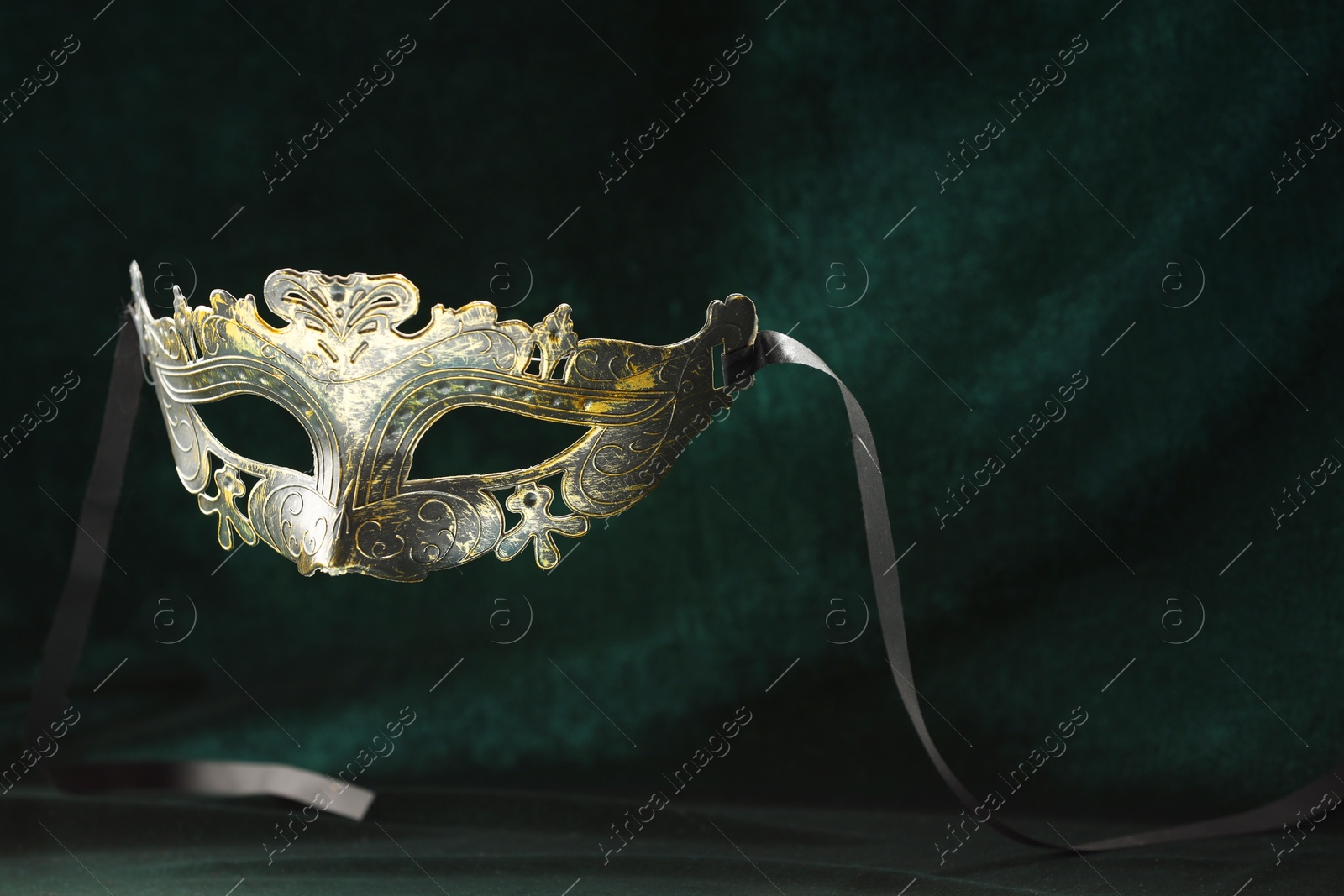 Photo of Theater arts. Venetian carnival mask against green fabric, space for text