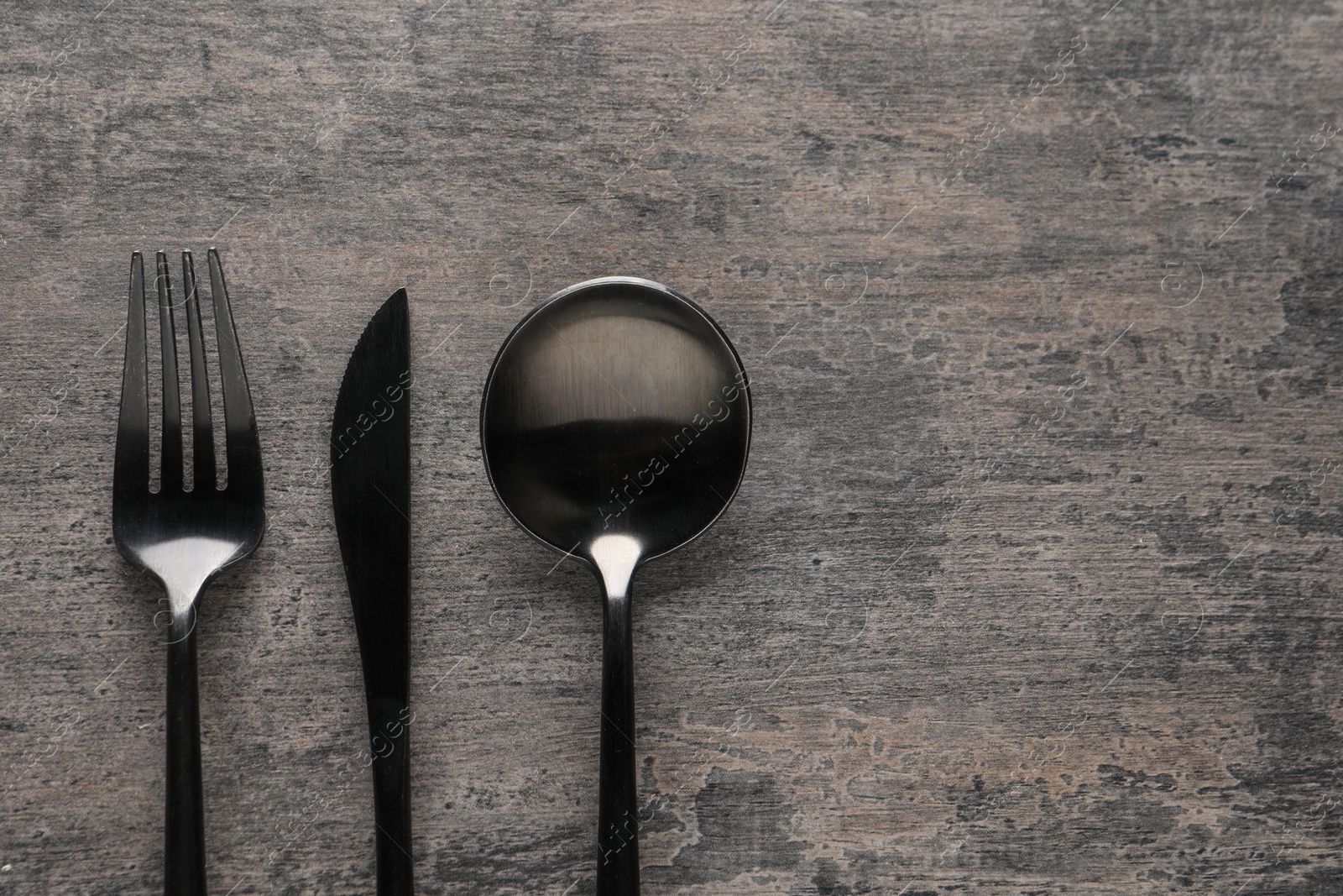 Photo of Stylish cutlery on grey table, flat lay. Space for text