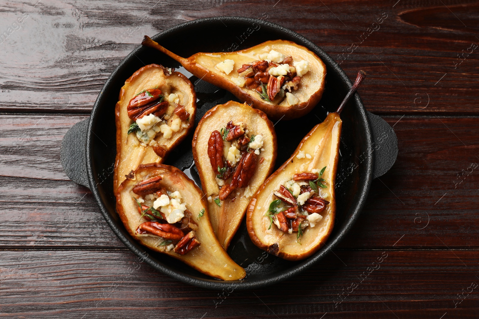 Photo of Delicious baked pears with nuts, blue cheese and honey on wooden table, top view