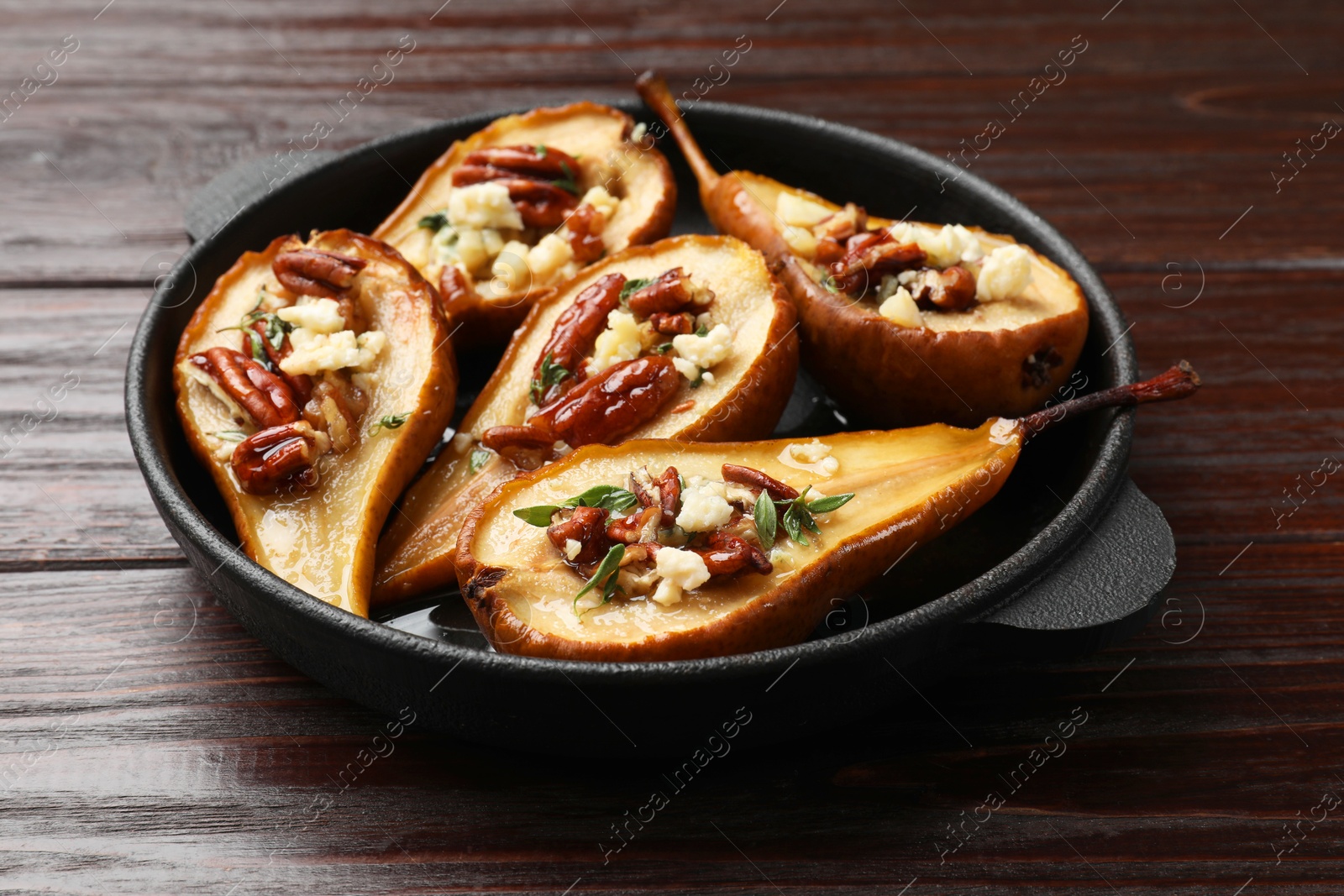 Photo of Delicious baked pears with nuts, blue cheese and honey on wooden table, closeup