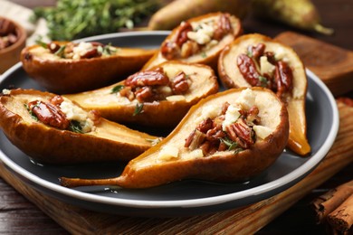 Photo of Delicious baked pears with nuts, blue cheese and honey on table, closeup