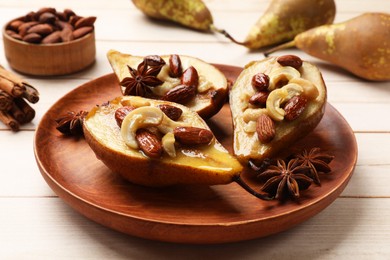 Photo of Delicious baked pears with nuts and anise stars on light wooden table, closeup