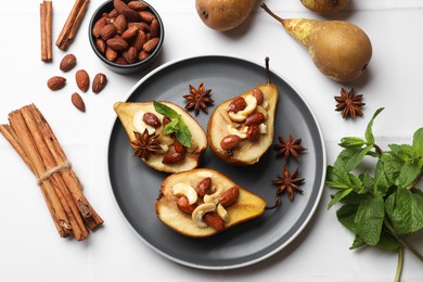 Delicious baked pears with nuts, mint and anise stars on white table, flat lay