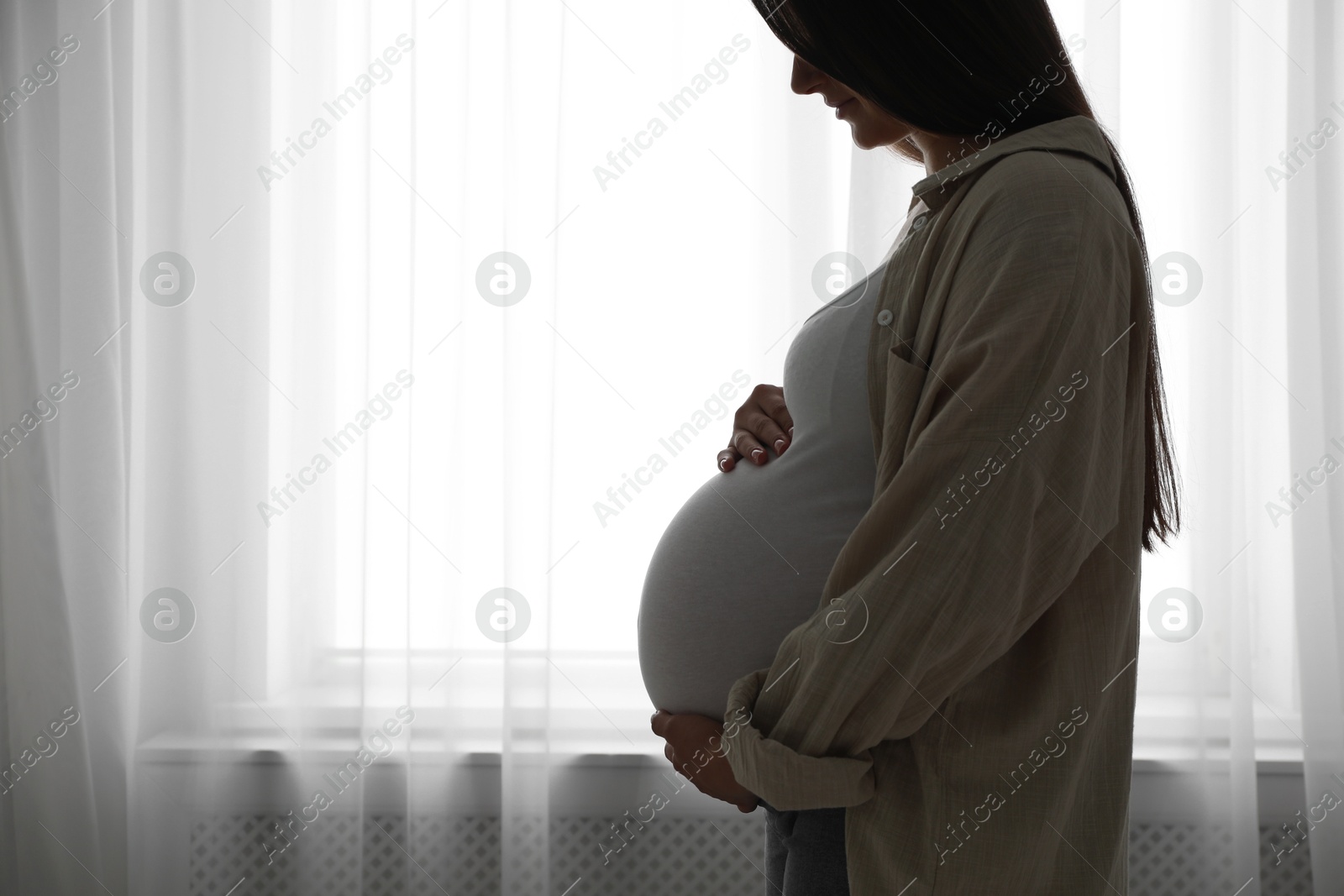 Photo of Beautiful pregnant woman at home, space for text