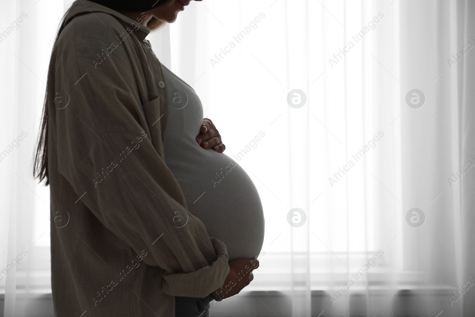 Photo of Beautiful pregnant woman at home, closeup. Space for text