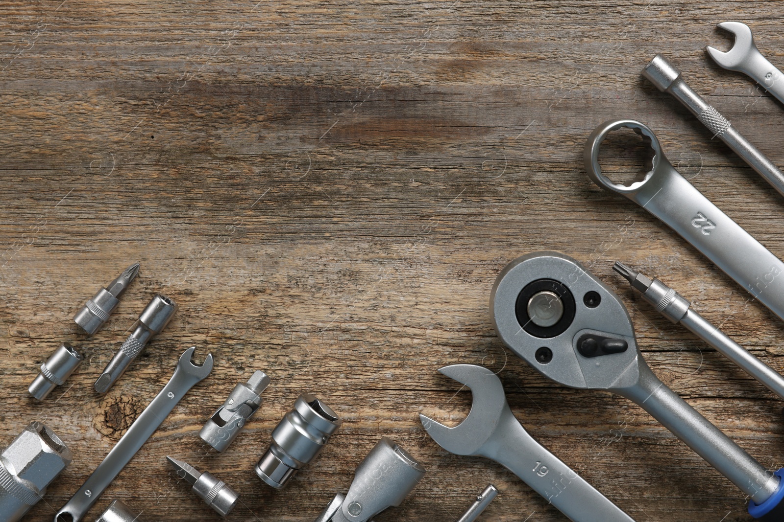 Photo of Different auto mechanic's tools on wooden table, flat lay. Space for text