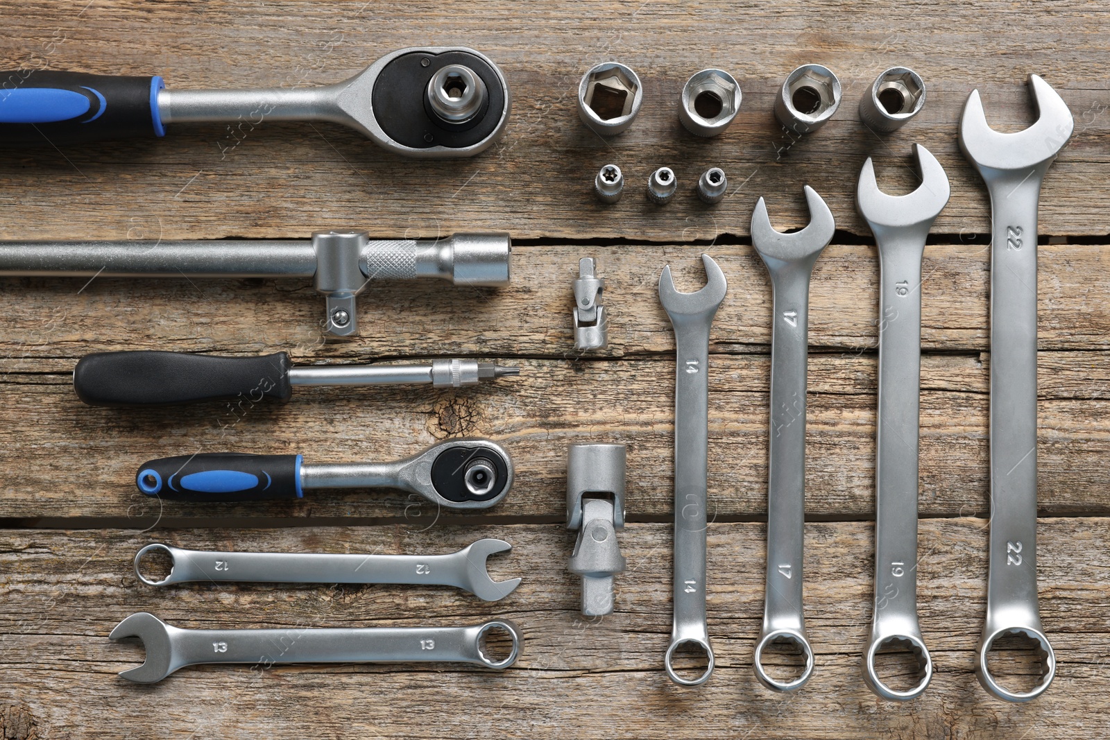 Photo of Different auto mechanic's tools on wooden table, flat lay