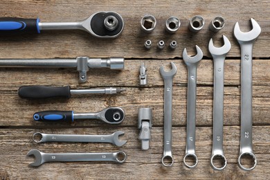 Different auto mechanic's tools on wooden table, flat lay