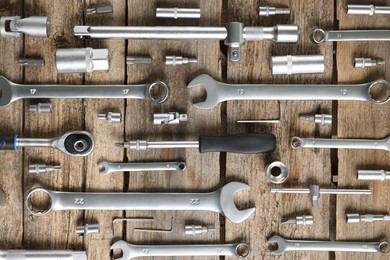 Photo of Different auto mechanic's tools on wooden table, flat lay